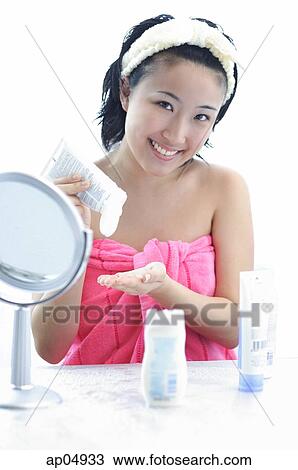 Young woman sitting at dressing table, smiling at camera View Large Photo Image Stock Image - Young woman sitting at dressing table, smiling at camera. Fotosearch