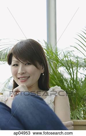 Stock Image - Young woman smiling at camera, portrait. Fotosearch