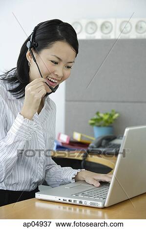 Young woman using hands free device, smiling View Large Photo Image Stock Photo - Young woman using hands free device, smiling. Fotosearch