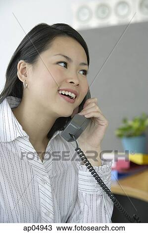 Young woman using telephone View Large Photo Image Stock Image - Young woman using telephone. Fotosearch