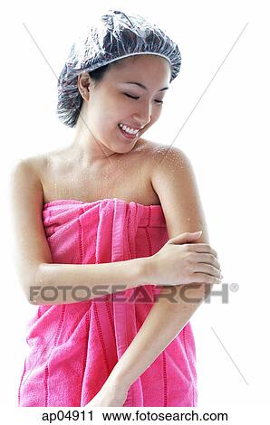 Young woman wearing shower cap and towel, applying moisturizer to arm View Large Photo Image Stock Image - Young woman wearing shower cap and towel, applying moisturizer to arm. Fotosearch