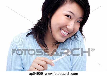 Young woman with toothbrush, smiling at camera View Large Photo Image Stock Photo - Young woman with toothbrush, smiling at camera. Fotosearch