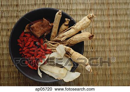 Stock Image - Bowl filled with Chinese medicinal herbs, high angle view. Fotosearch