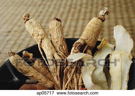 Stock Photo - Bowl filled with Chinese medicinal herbs, close-up. Fotosearch