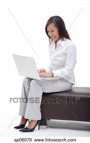 Business woman sitting on bench, using laptop View Large Photo Image Stock Photo - Business woman sitting on bench, using laptop. Fotosearch
