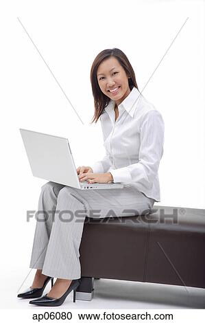 Business woman sitting on bench with laptop, smiling at camera View Large Photo Image Stock Image - Business woman sitting on bench with laptop, smiling at camera. Fotosearch