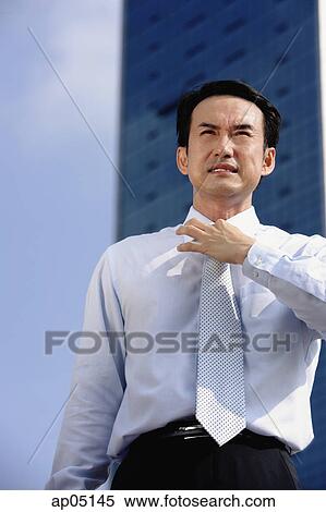 Businessman frowning, adjusting tie View Large Photo Image Stock Photography - Businessman frowning, adjusting tie. Fotosearch