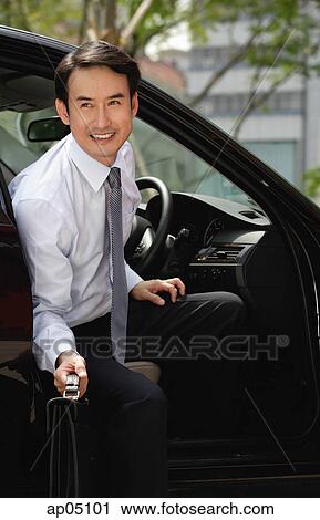 Businessman getting out of car, smiling View Large Photo Image Stock Image - Businessman getting out of car, smiling. Fotosearch