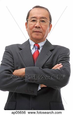 Stock Photograph - Businessman looking at camera, arms crossed. Fotosearch