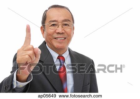 Businessman looking at camera, raising finger View Large Photo Image Stock Photo - Businessman looking at camera, raising finger. Fotosearch