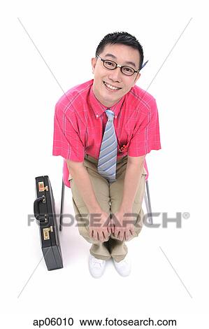 Businessman sitting on chair, smiling at camera, briefcase next to him View Large Photo Image Stock Image - Businessman sitting on chair, smiling at camera, briefcase next to him. Fotosearch