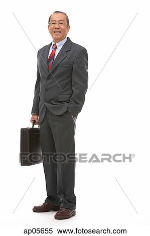 Stock Photography - Businessman standing with briefcase, portrait. Fotosearch