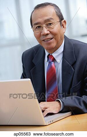 Businessman with laptop, smiling at camera View Large Photo Image Stock Image - Businessman with laptop, smiling at camera. Fotosearch