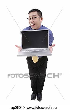 Businessman with open laptop, facing camera View Large Photo Image Stock Photo - Businessman with open laptop, facing camera. Fotosearch