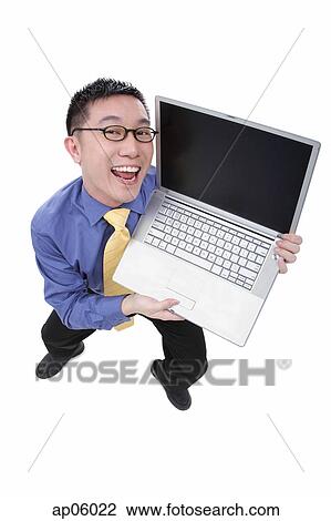 Businessman with open laptop, looking at camera, smiling View Large Photo Image Stock Image - Businessman with open laptop, looking at camera, smiling. Fotosearch