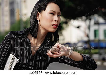 Businesswoman checking the time, frowning View Large Photo Image Stock Photo - Businesswoman checking the time, frowning. Fotosearch