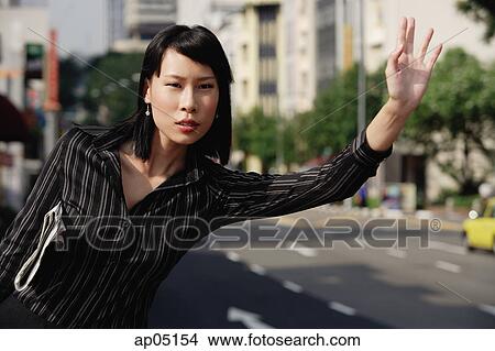 Picture - Businesswoman hailing a cab. Fotosearch