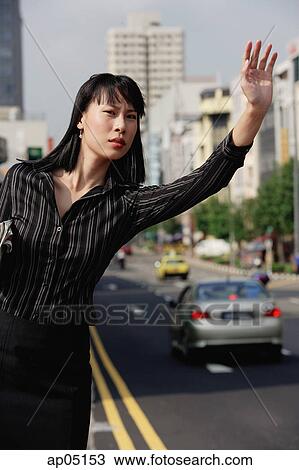 Businesswoman hailing a taxi, frowning View Large Photo Image Stock Image - Businesswoman hailing a taxi, frowning. Fotosearch