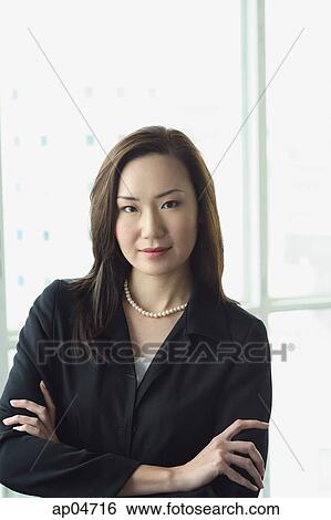 Businesswoman looking at camera, arms crossed View Large Photo Image Stock Photograph - Businesswoman looking at camera, arms crossed. Fotosearch