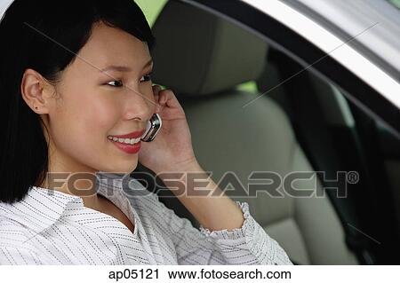 Businesswoman sitting in car using mobile phone View Large Photo Image Stock Image - Businesswoman sitting in car using mobile phone. Fotosearch