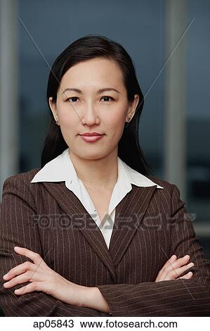 Stock Image - Businesswoman with arms crossed, portrait. Fotosearch