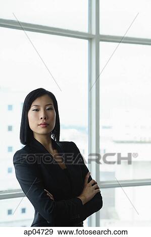 Stock Photo - Businesswoman with arms crossed, looking at camera. Fotosearch
