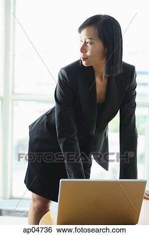 Businesswoman with laptop, standing, looking away View Large Photo Image Stock Photograph - Businesswoman with laptop, standing, looking away. Fotosearch