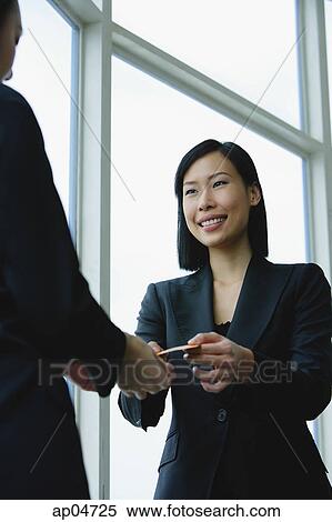 Stock Photography - Businesswomen exchanging business cards. Fotosearch