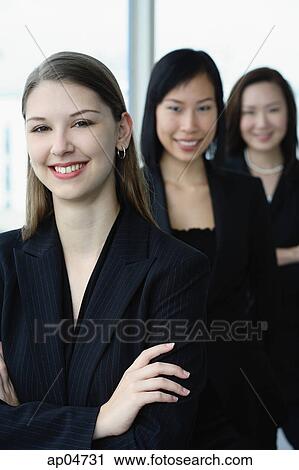 Businesswomen in a row, smiling at camera, Caucasian woman in the front View Large Photo Image Stock Image - Businesswomen in a row, smiling at camera, Caucasian woman in the front. Fotosearch