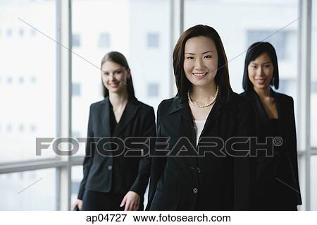 Businesswomen in a row, smiling at camera View Large Photo Image Stock Photo - Businesswomen in a row, smiling at camera. Fotosearch