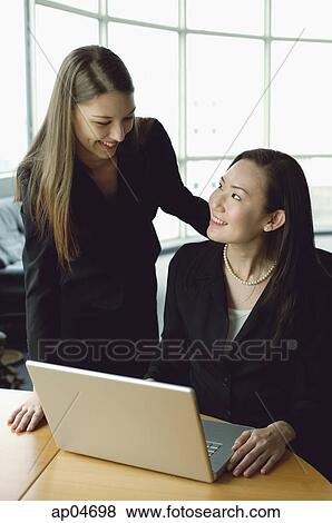 Stock Photo - Businesswomen in front of laptop. Fotosearch