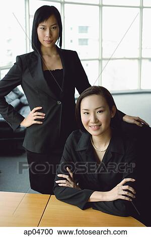 Stock Image - Businesswomen looking at camera, portrait. Fotosearch
