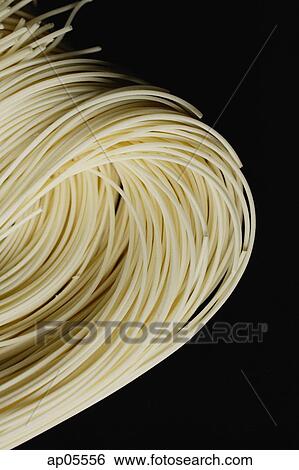 Stock Photograph - Chinese noodles against black background, close up. Fotosearch