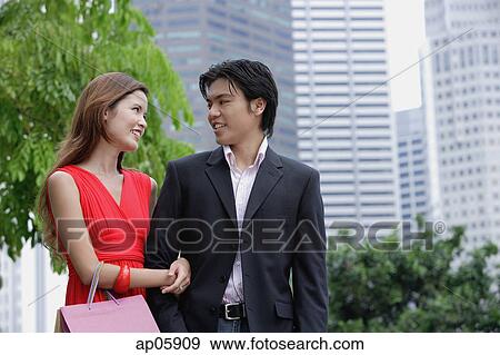 Couple arm in arm, looking at each other View Large Photo Image Stock Photo - Couple arm in arm, looking at each other. Fotosearch
