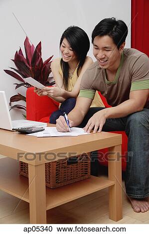 Couple at home in living room, doing finances View Large Photo Image Stock Image - Couple at home in living room, doing finances. Fotosearch