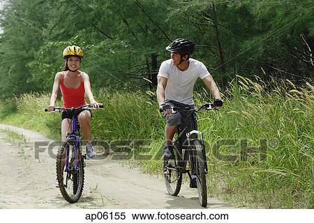 Couple cycling side by side View Large Photo Image Stock Photography - Couple cycling side by side. Fotosearch