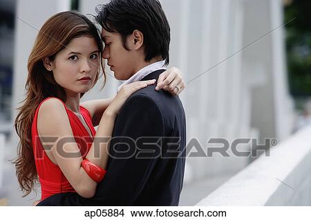 Couple embracing, woman looking at camera View Large Photo Image Picture - Couple embracing, woman looking at camera. Fotosearch