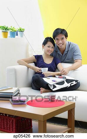 Stock Photograph - Couple in living room, looking at camera. Fotosearch