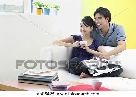 Stock Photography - Couple in living room, looking away. Fotosearch