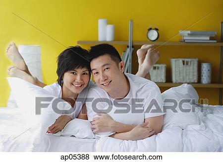 Couple lying on bed, portrait View Large Photo Image Stock Photo - Couple lying on bed, portrait. Fotosearch