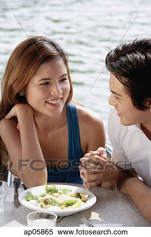 Couple sitting at outdoor cafe, looking at each other View Large Photo Image Stock Photography - Couple sitting at outdoor cafe, looking at each other. Fotosearch