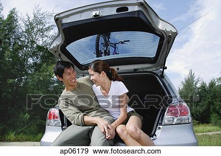 Couple sitting in boot of car View Large Photo Image Stock Photo - Couple sitting in boot of car. Fotosearch