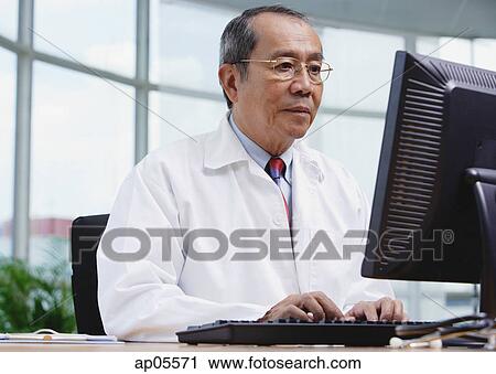 Doctor in office, using desktop computer View Large Photo Image Stock Image - Doctor in office, using desktop computer. Fotosearch