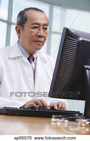 Doctor using desktop computer View Large Photo Image Stock Image - Doctor using desktop computer. Fotosearch