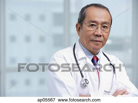 Doctor with arms crossed, looking at camera View Large Photo Image Stock Photo - Doctor with arms crossed, looking at camera. Fotosearch