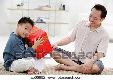 Father and son at home, boy holding big gift box View Large Photo Image Stock Image - Father and son at home, boy holding big gift box. Fotosearch