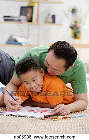 Father and son at home, drawing on sketch pad View Large Photo Image Stock Photograph - Father and son at home, drawing on sketch pad. Fotosearch