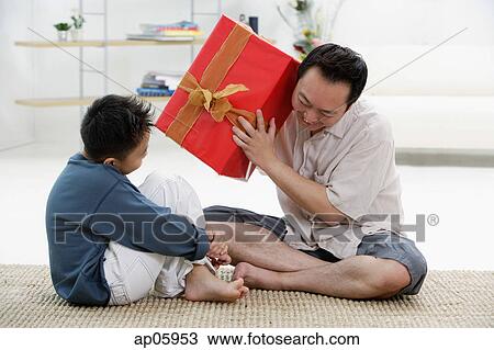 Father and son at home, father holding big gift box View Large Photo Image Stock Image - Father and son at home, father holding big gift box. Fotosearch