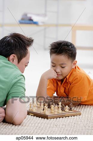 Father and son at home, playing chess View Large Photo Image Picture - Father and son at home, playing chess. Fotosearch