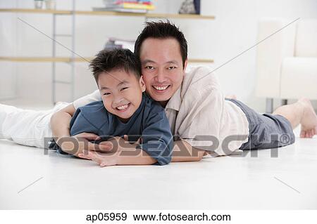 Father and son lying on floor, embracing, portrait View Large Photo Image Stock Photo - Father and son lying on floor, embracing, portrait. Fotosearch